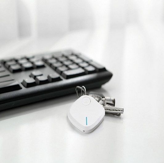A key finder along with keys kept near a keyboard