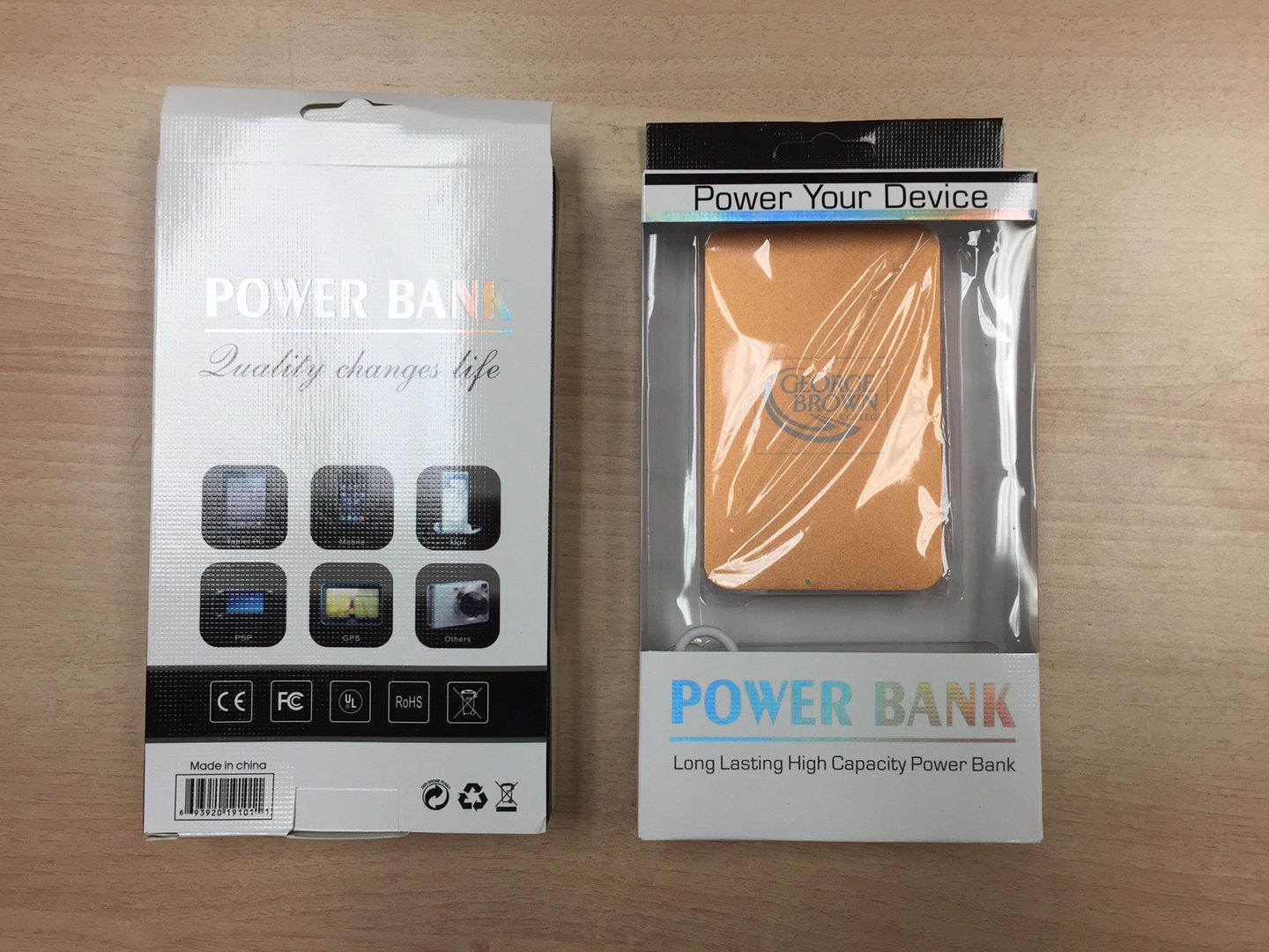 A Power Bank in a Plastic Case Beside a Box