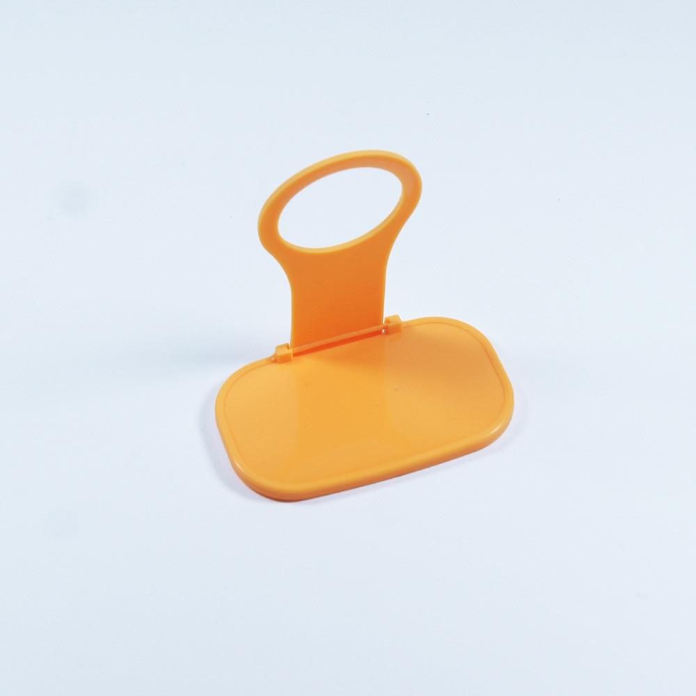 An orange color phone grip on white sheet
