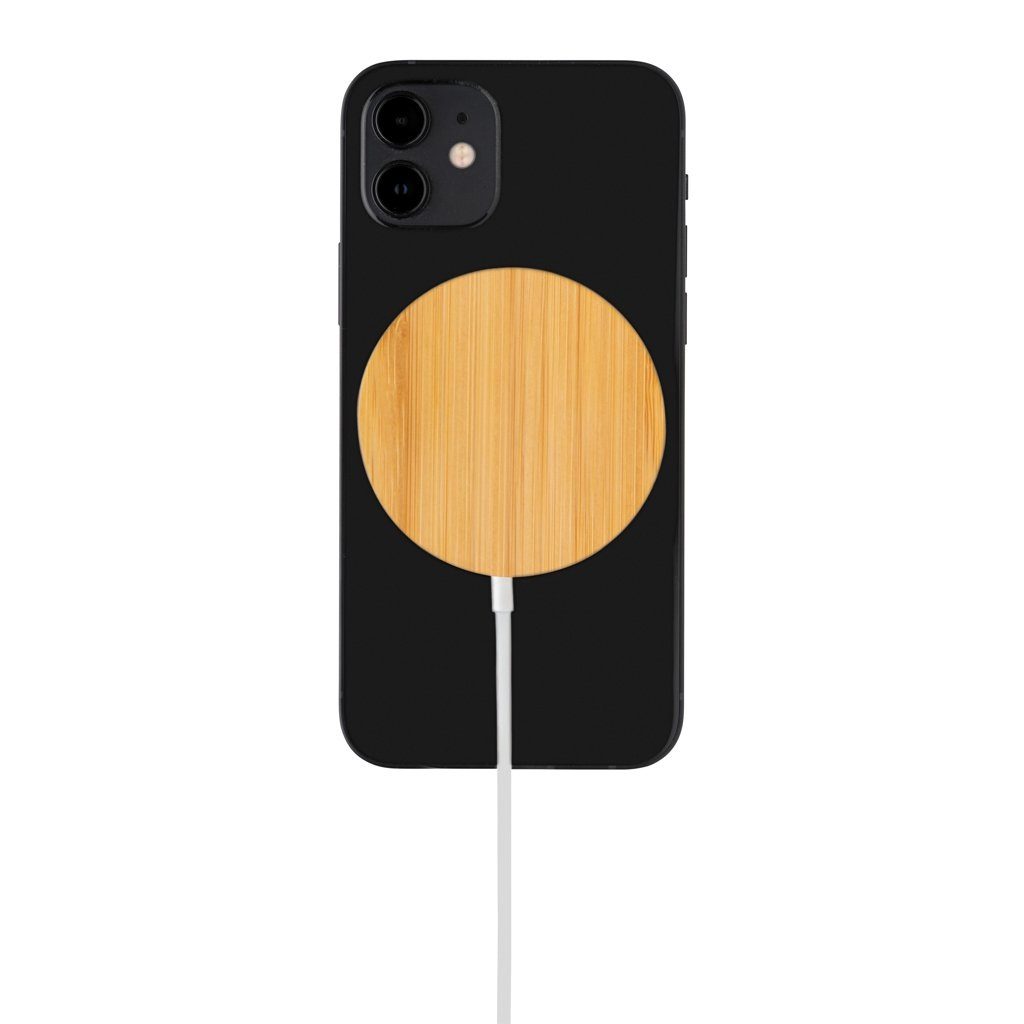 A mobile phone with a round wooden shaped wireless charger