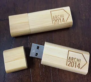 Two wooden Archi 2014 USB drives placed on the desk